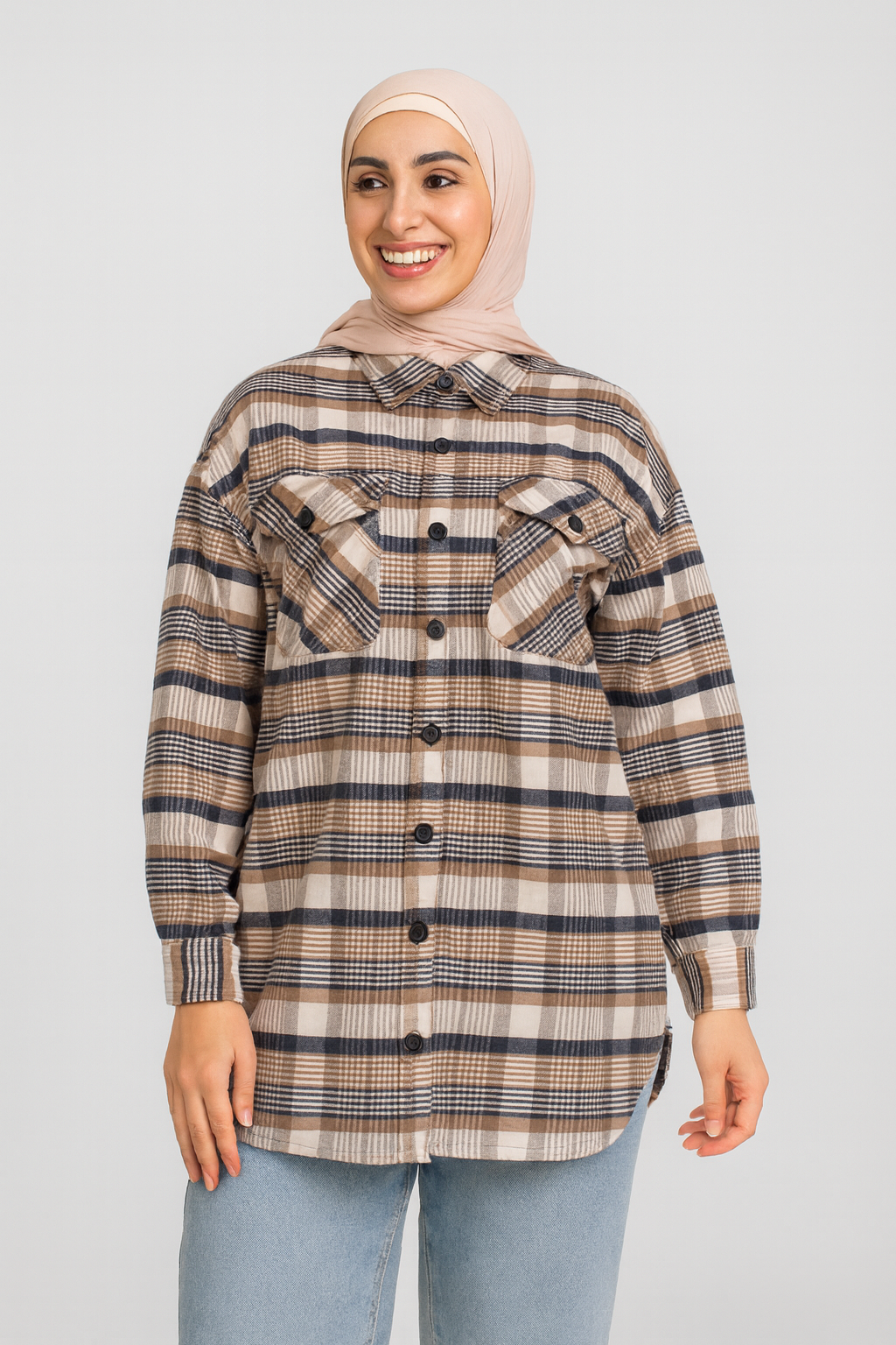 Woman wearing a plaid shirt and hijab on a plain background